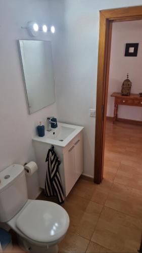 a bathroom with a white toilet and a sink at Casita Blum in La Asomada