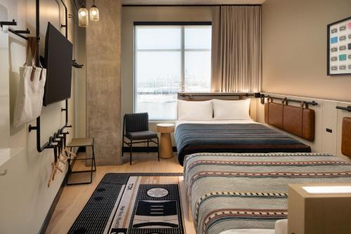 a hotel room with two beds and a chair at Moxy Atlanta Downtown in Atlanta