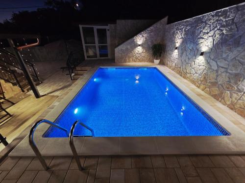 a swimming pool in a house at night at Adria Stone House in Grižane
