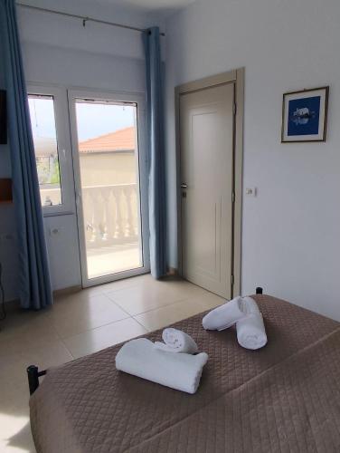 a bedroom with a bed with two towels on it at ChristAlex Guesthouse in Himare