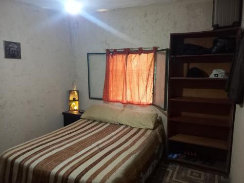 a small bedroom with a bed and a window at El PRADO in Alta Gracia