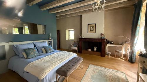 a bedroom with a large bed and a fireplace at Les Hauts de Sauliès - Chambre et Table d'Hôtes de charme in Vers
