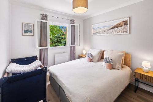 a bedroom with a bed and a blue chair at Villa La Dorada, Normandy in Ver-sur-Mer