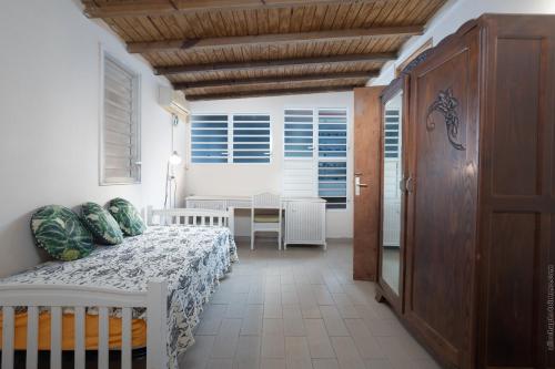 a bedroom with a bed and a table and windows at écrin de Monpierre in Brion
