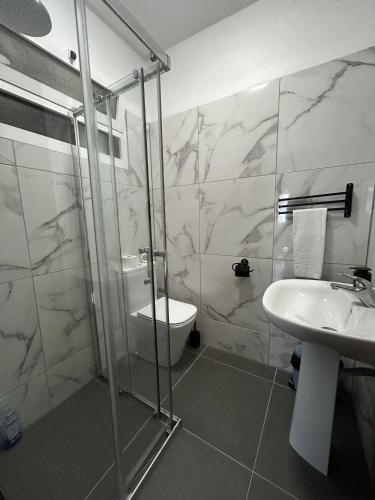 a bathroom with a shower and a sink and a toilet at Casa reizinho in Santana