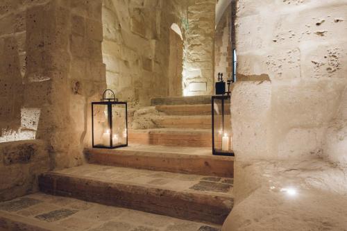 a stone hallway with stairs with lights and candles at Il Palazzotto I Residence & Winery in Matera
