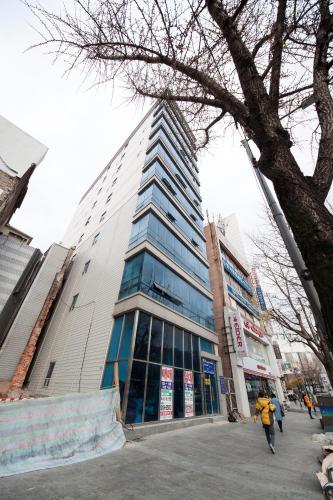 a tall building with people walking in front of it at K-Guesthouse Premium Nampo 1 in Busan