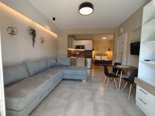 a living room with a blue couch and a kitchen at SeaEsta Vasiliki 1 in Póndi