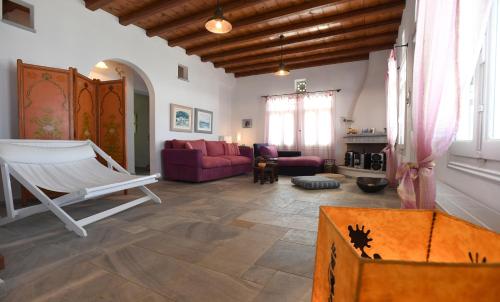 a living room with a couch and a chair at Tinos Sky View Villa in Arnados