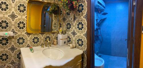 a bathroom with a sink and a mirror and a shower at Nhà Bên Suối Retreat in Làng Tè