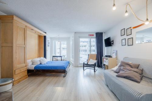 a bedroom with a bed and a couch at Le loft du Hameau in Stoneham