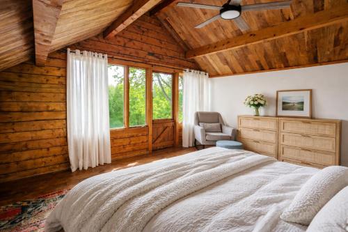 a bedroom with a large bed and a chair at Log Cabin with Mountain Views in Palmer