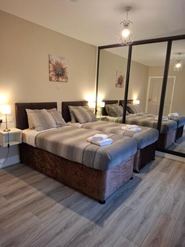 a bedroom with two beds and a large mirror at Coaches Corner - Modern Suite - Sleeps 3 - Flexible Beds - Parking - Near Town in Castleblayney