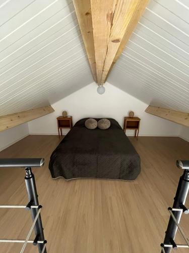 a bedroom with a black bed in a attic at Chez Raphaël et Hiba in Nesles