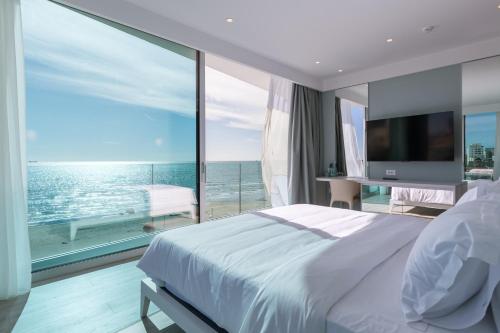 a bedroom with a large white bed and a large window at Nava Star Hotel in Durrës