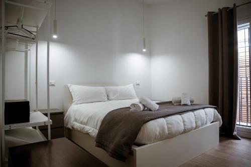 a bedroom with a bed with white sheets and a window at dellarocca4 in Cefalù