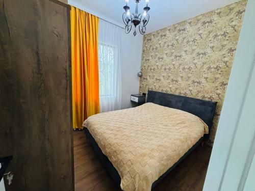 a bedroom with a bed and an orange curtain at Green Villa in Kobuleti