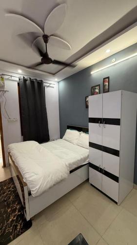 a bedroom with a bed with a ceiling fan at Indigo Inn in Malhour