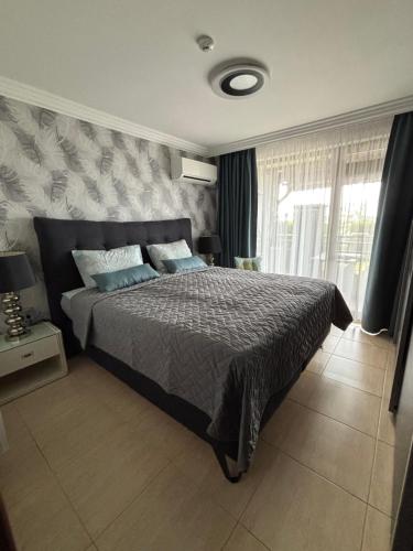 a bedroom with a large bed and a window at Beachfront Apartment with Garden at Venid Sandy Beach - Apartment Marina Dinevi View in Sveti Vlas