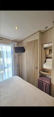 a bedroom with a bed and a closet and a bed at Luxury 3 bedroom caravan hobourne Devon bay with hot tub in Goodrington