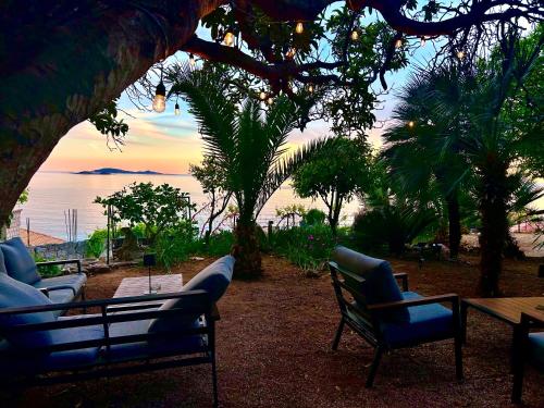 a patio with chairs and a table with a view of the ocean at Old Stone House in Mlini