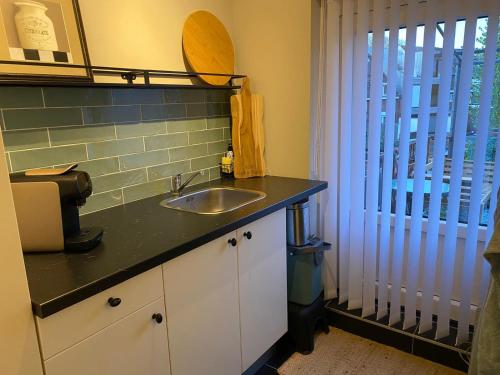 a kitchen counter with a sink and a window at B&B Pied à Pieter in Maastricht