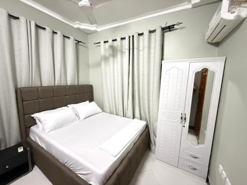a small bedroom with a bed and a window at Rejao Homes in Dar es Salaam