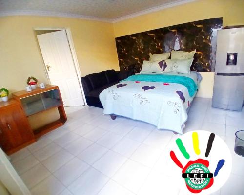 a bedroom with a bed and a refrigerator in it at Lefi Recreational Park in Wolmaranstad