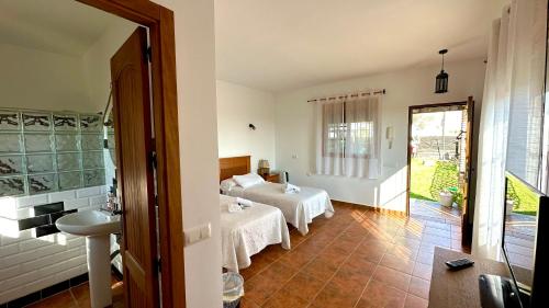 a bedroom with two beds and a sink in a room at Vista al faro in Cádiz