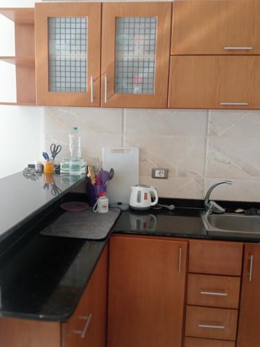 a kitchen with wooden cabinets and a black counter top at Hurghada, El-Marina in Hurghada