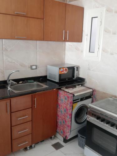 a small kitchen with a sink and a microwave at Hurghada, El-Marina in Hurghada