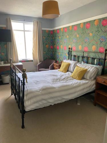 a bedroom with a large bed with floral wallpaper at Newberry Beach lodge in Combe Martin