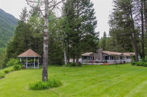 a large yard with a house and a gazebo at Secluded River View Hideaway in Hungry Horse