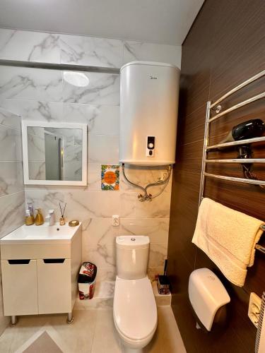 a bathroom with a white toilet and a sink at Апарт-готель HAPPY in Fontanka