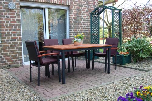 a wooden table and chairs on a patio at Ferienwohnung Behner in Greven