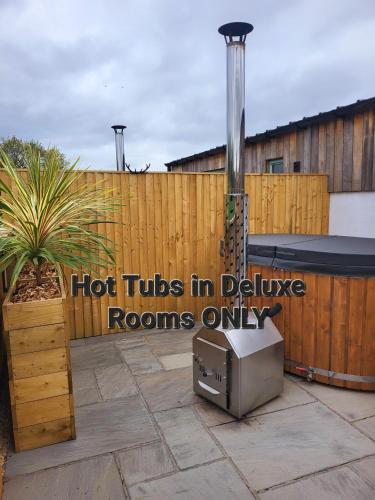 a hot tub in a backyard with a wooden fence at The Old Barn in Hanbury