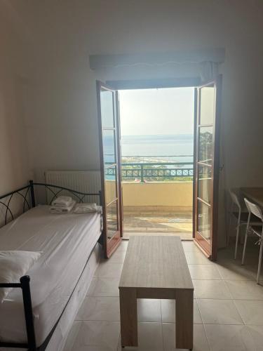a bedroom with a bed and a table and a view of the ocean at Filonoe apartment in Gialiskari