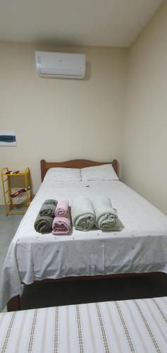 a white bed with towels on it in a room at Studio Figueira, Sol in Santarém