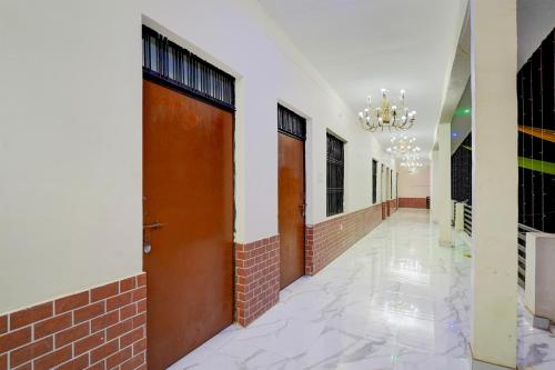 a corridor of a building with two doors and a chandelier at SPOT ON Hotel MS Grand in Lucknow