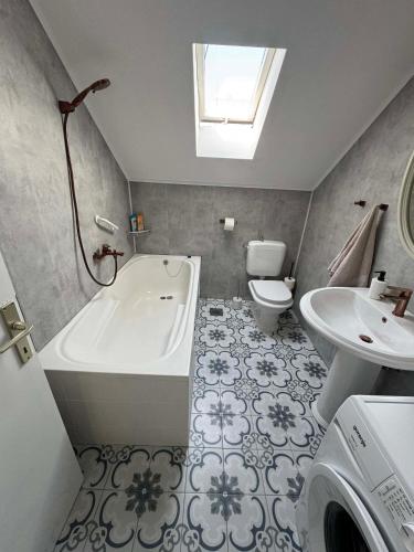 a bathroom with a tub and a toilet and a sink at U prolazu in Đakovo
