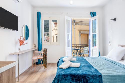 a hotel room with a bed with a blue blanket at Twelve 12 Islands in Symi