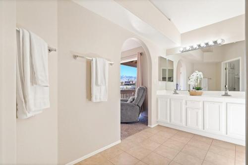 a white bathroom with a sink and a chair at The AZ Escape in Tucson