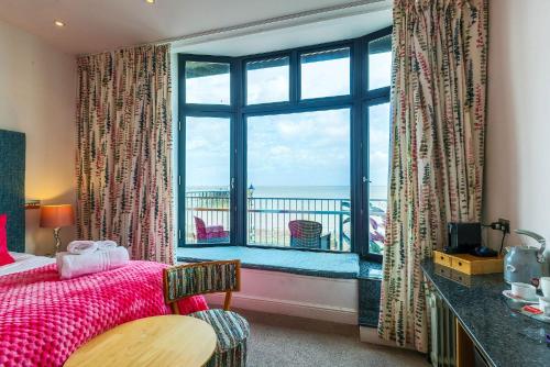 a bedroom with a window with a view of the ocean at Beachcliff Rooms & Apartments in Cardiff
