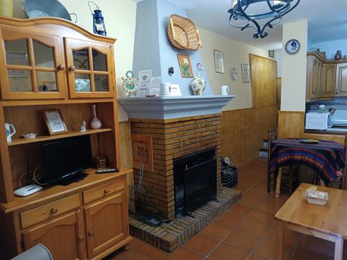 a living room with a fireplace and a tv at Casa Margarita in Bubión