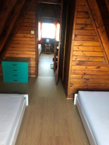 a room with two beds in a wooden cabin at Joyosada - Ferienhäuser in Seenlandschaft in Prusim