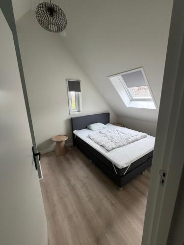 a small bedroom with a bed and a window at Burgvliet41 in Oostkapelle