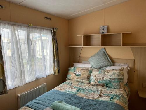 a small bedroom with a bed and a window at 50 Seaview Ingoldmells in Ingoldmells