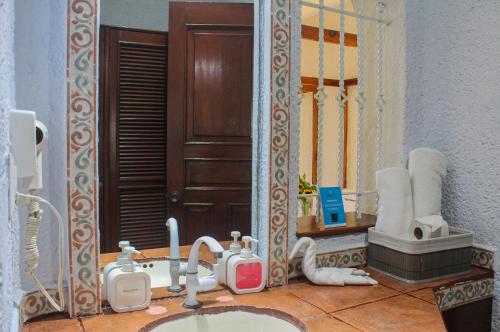 a bathroom with a sink and a mirror at Chez Waffle Hotel in Puerto Aventuras
