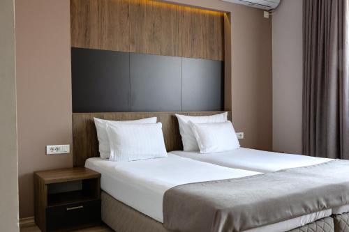 a bedroom with two beds with white pillows at ZARO Apartments in Bitola