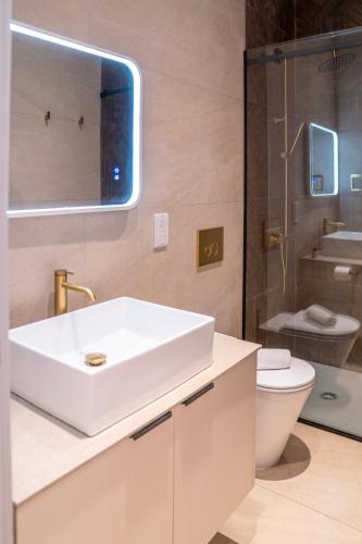 a bathroom with a white sink and a toilet at Epos by the Sea in Larnaca